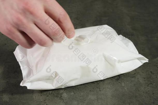 手拿湿的抗菌的餐巾出局关于包装.关在上面.