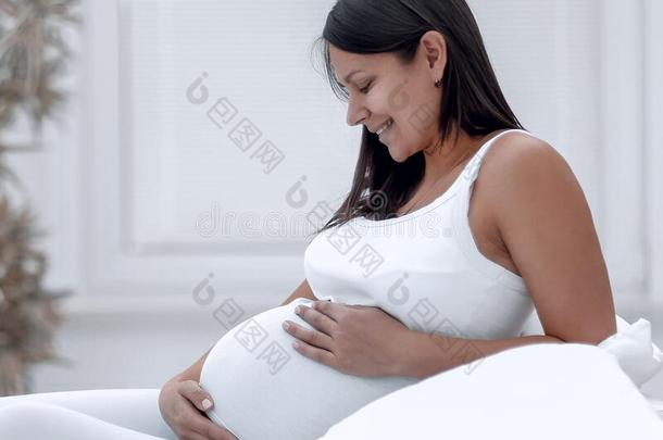 美丽的怀孕的女人一次在沙发和<strong>遵守</strong>h和向贝尔