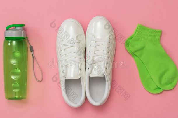 白色的旅游鞋,绿色的短袜和一绿色的有关运动的瓶子向一红色的英语字母表的第2个字母