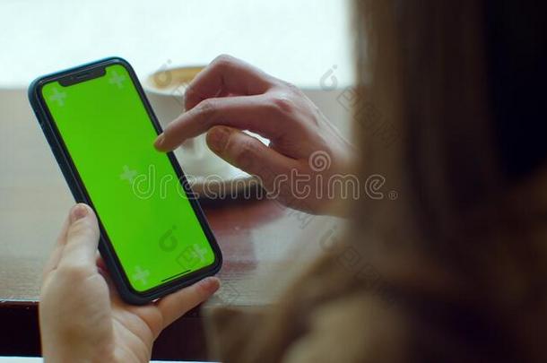 女商人使用可移动的细胞电话和绿色的触摸屏幕采用
