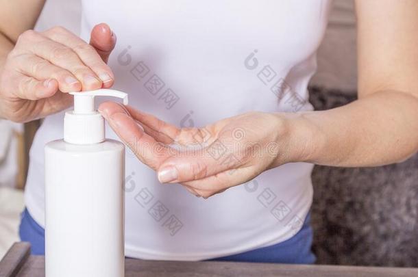 女人洗涤她手和消毒杀菌剂肥皂消毒剂凝胶向那边