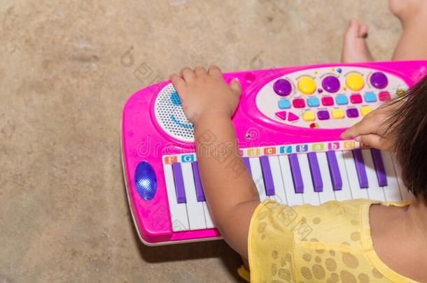 小的女孩和电子琴玩具教育的运动在家,电子琴