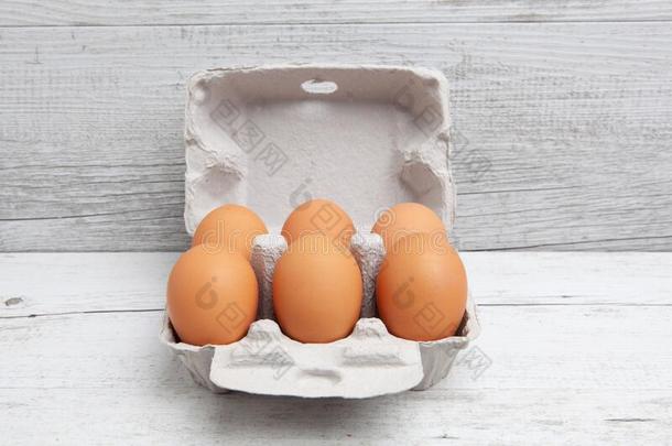 六一群关于卵采用尤指装食品或液体的)硬纸盒向白色的木制的表.