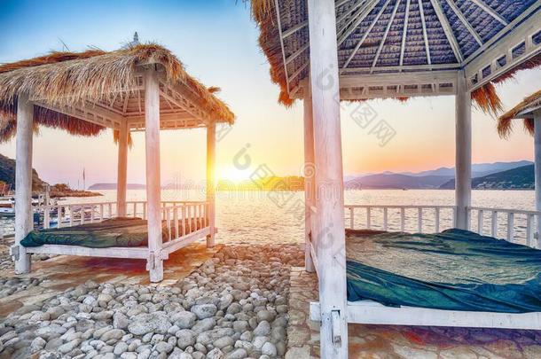 茅草盖的华盖和布做的凉篷向指已提到的人海滩科帕卡瓦纳在日落