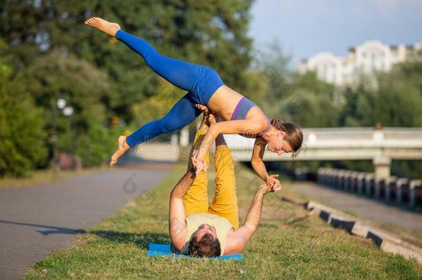 年幼的像运动家的对做acrobat杂技演员瑜伽练习