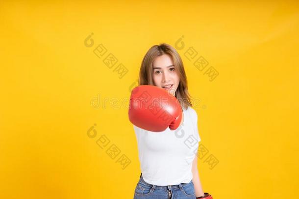 肖像幸福的年幼的亚洲人女人和拳击手套用拳猛<strong>击打</strong>