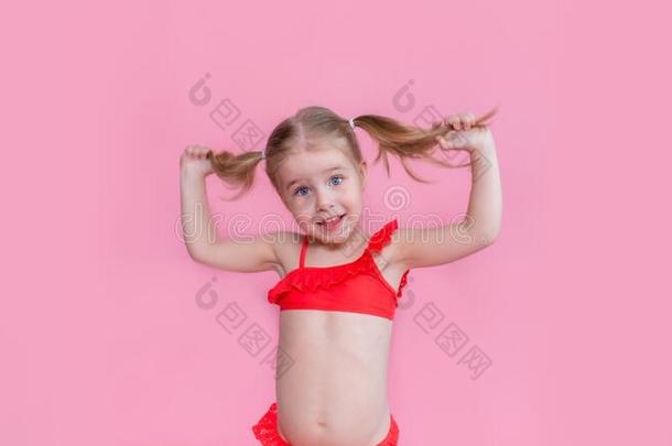 美丽的小的亚麻色的女孩和两个马术故事采用一红色的游泳衣