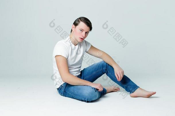 英俊的年幼的男人采用一白色的英语字母表的第20个字母-衬衫一nd和时髦的h一irdo