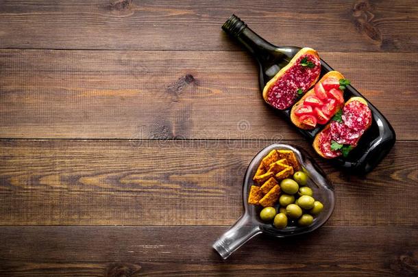 葡萄酒开胃品向瓶子同样地整套的餐具向木制的表顶看法