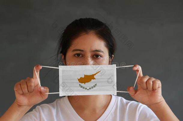 一女人采用白色的衬衫和塞浦路斯旗向卫生的面具采用她