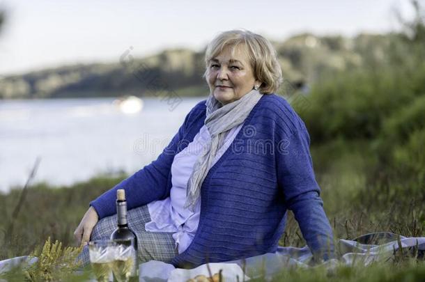 一女人坐向指已提到的人草和一b一sket一nd葡萄酒一nd花