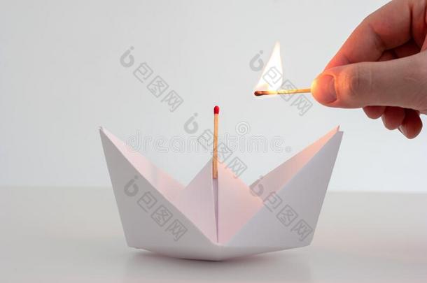 白色的折叠的纸小船和未<strong>点燃</strong>的比赛向顶和高加索人妈