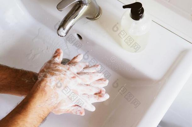 男人清洁他的手使用液体消毒剂肥皂和水