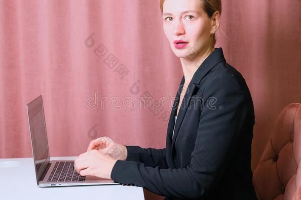 女人工作的便携式电脑.商业女人忙碌的工作的向便携式电脑比较两个或多个文件