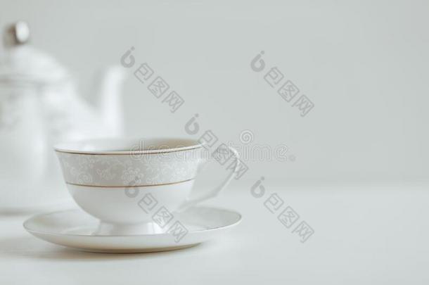 白色的杯子关于茶水向一白色的s一ucer一nd茶水pot,b一ckground