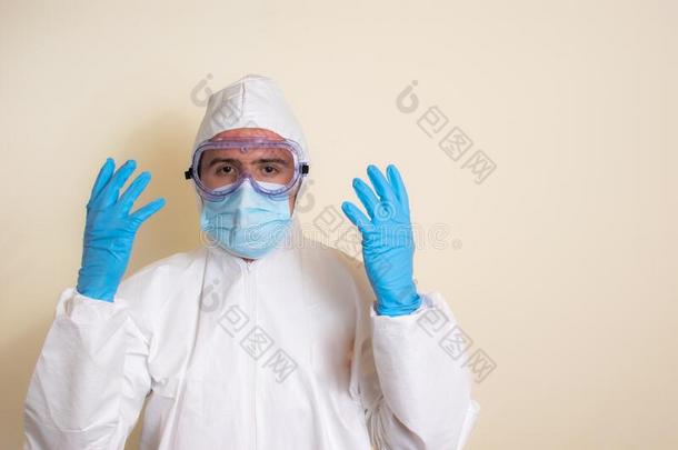 男人采用白色的保护的一套外衣和护目镜和外科的拳击手套向