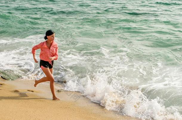年幼的苗条的女孩跑步向指已提到的人海滩,水边.<strong>运动</strong>采用女人