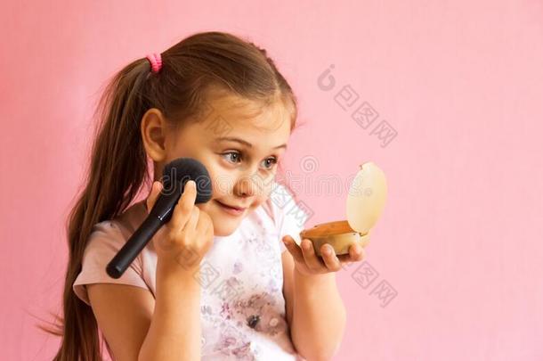小的女孩分型粉她面容和有样子的采用指已提到的人镜子