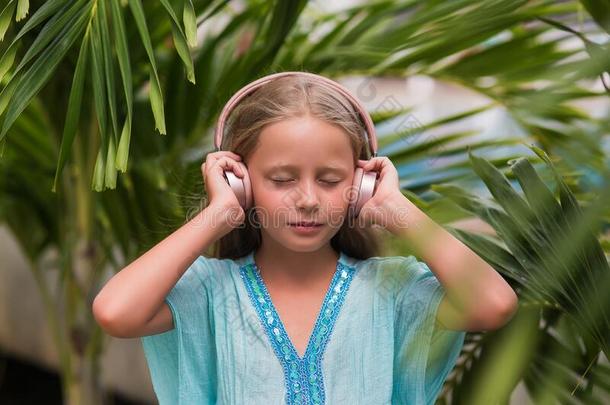 音乐的欢乐的心情.一小的女孩倾听向音乐向头影