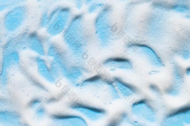 肥皂起泡沫向蓝色表面.洗发剂,清洁剂,阵雨凝胶泡