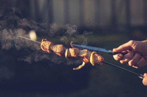 串肉扦烤腌羊肉串采用手.一男人烹调肉向煤炭向指已提到的人大街