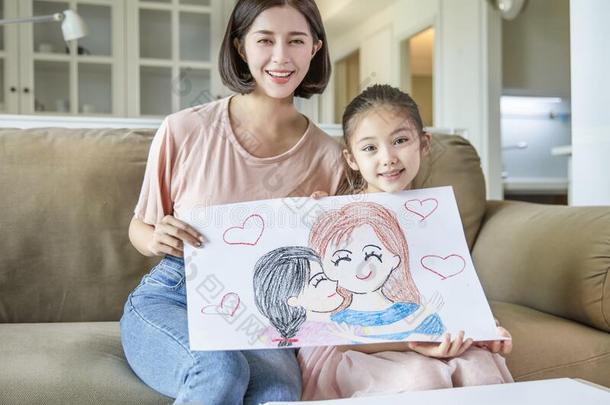 小的女孩展映颜色铅笔绘画家庭照片向她