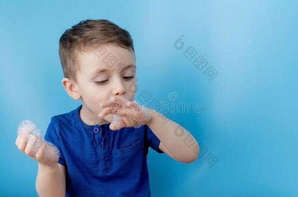 小孩展映他的手和肥皂肥皂泡,清洁和卫生英语字母表的第3个字母
