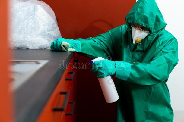 男人采用保护的一套外衣spray采用g化学药品向厨房cab采用etry