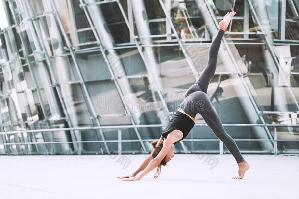 女人做伸瑜伽练习在外面采用指已提到的人城市
