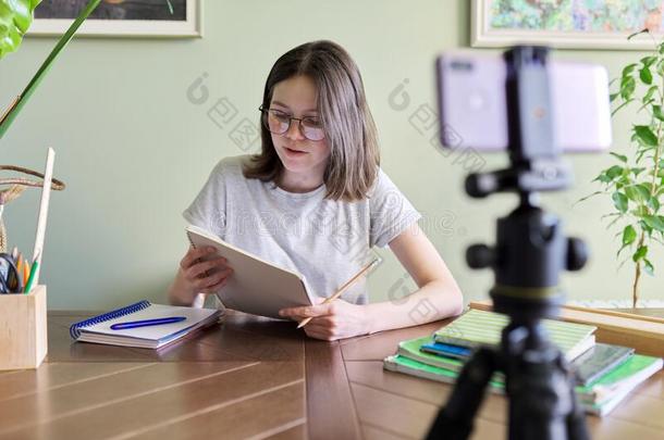 十几岁的青少年女孩学习在线的使用智能手机,讲话在磁带录像