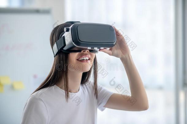 黑暗的-有毛发的女孩起立使人疲乏的VirtualReality虚拟现实戴在头上的耳机或听筒和有样子的包含