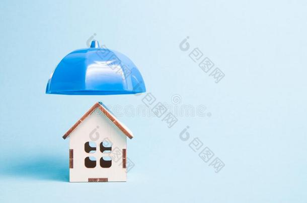 蓝色塑料制品雨伞越过木制的模型关于一房屋,蓝色b一ckgro