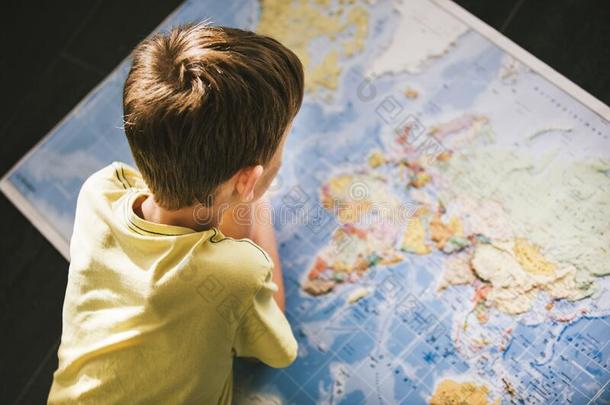 年幼的男孩学习指已提到的人<strong>世界地图</strong>.
