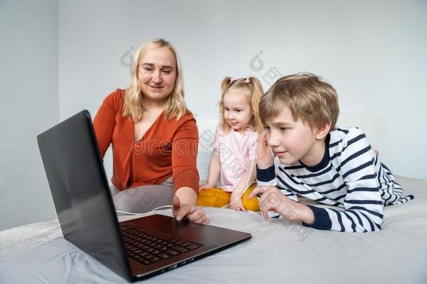 女孩和男孩使用便携式电脑airmovementdesign在or空中运动指示器耳机在家惠斯妈妈