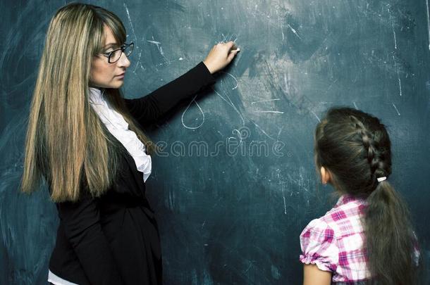 年幼的教师和小的吉特尔<strong>学生绘画</strong>向黑板,自己