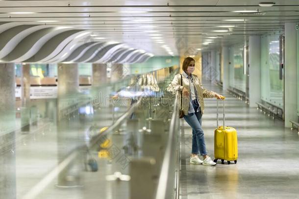 女人和行李刺在空的机场末期的由于向日冕