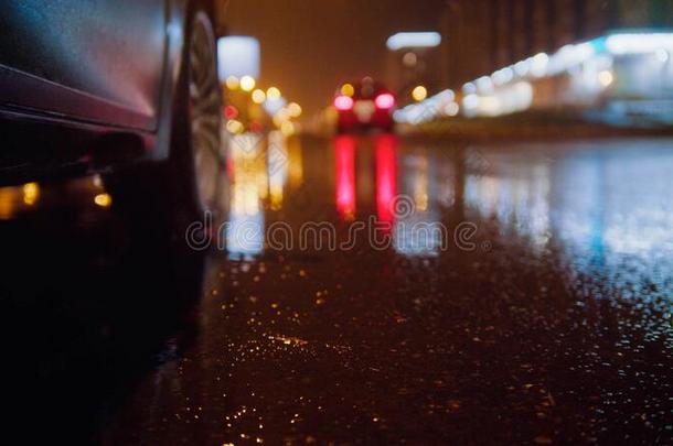 黑的汽车向指已提到的人湿的下雨的路