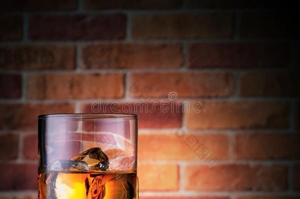 玻璃关于威士忌酒或波旁威士忌和冰立方形的东西向砖墙后座议员