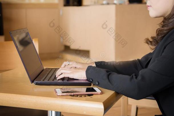 女人使用便携式电脑采用咖啡馆关在上面.
