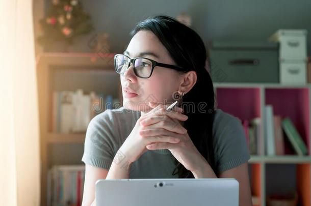 女人沉思的关于使工作在家办公室书桌便携式电脑