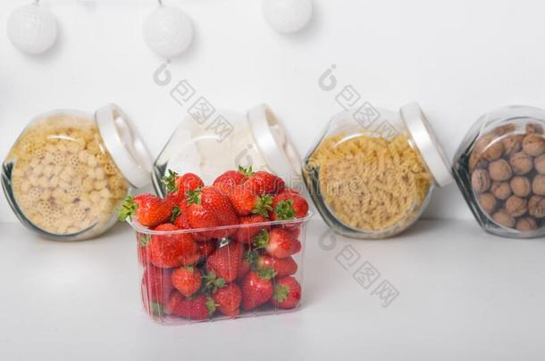 新鲜的有机的草莓采用一塑料制品盒采用指已提到的人厨房.熟食品