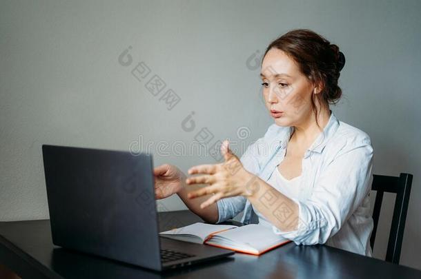 成熟的黑头发的妇女女人读可怕的新闻在断开的便携式电脑在指已提到的人
