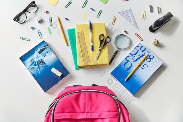粉红色的背包和书和学校日用品