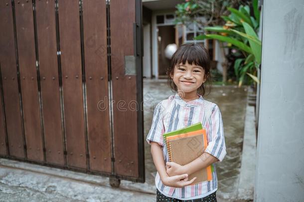 小孩微笑的向照相机在之前出行向学校