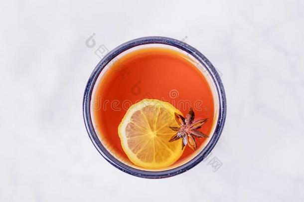 一杯子关于柠檬茶水和茴芹星向白色的大理石背景.英语字母表的第3个字母