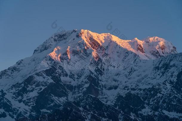 红色的早晨日出光越过安纳布尔那山南方山山峰竞争