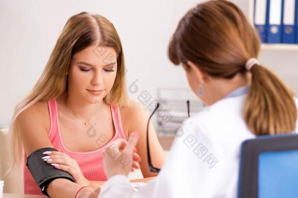 年幼的美丽的女人拜访医生为血压