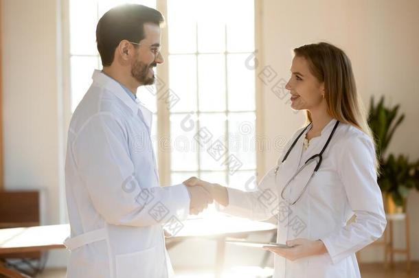 不同的医生握手获得了解在工作场所