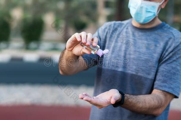 男人使用手消毒杀菌剂为消毒在户外