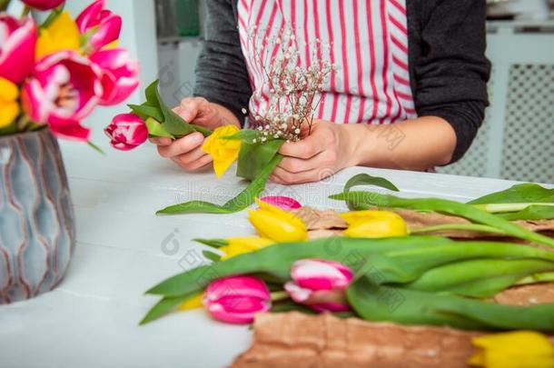 不面容年幼的男人制造春季花束使用郁金香.在线的自己